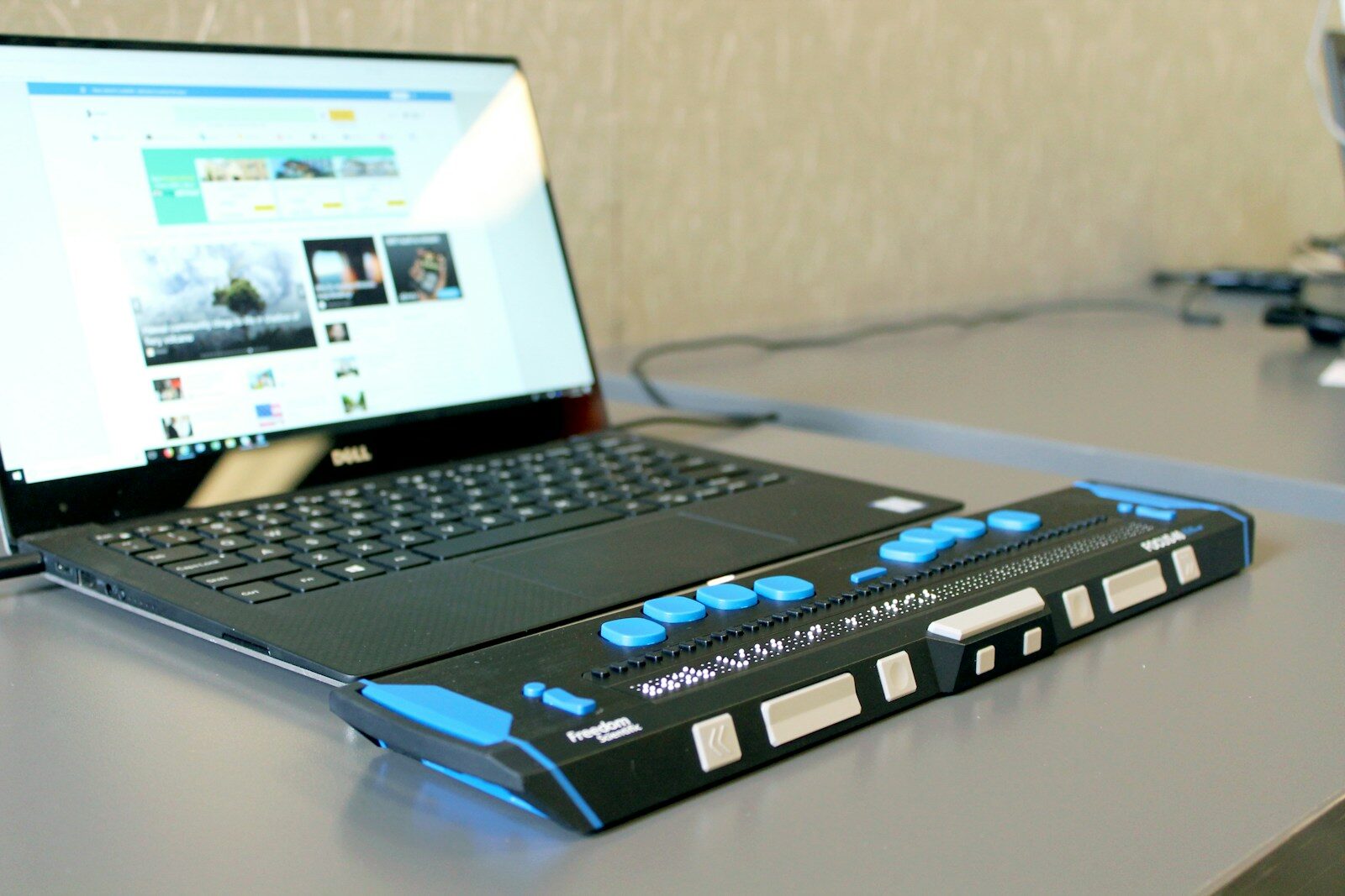 a laptop computer sitting on top of a desk with an accessibility device